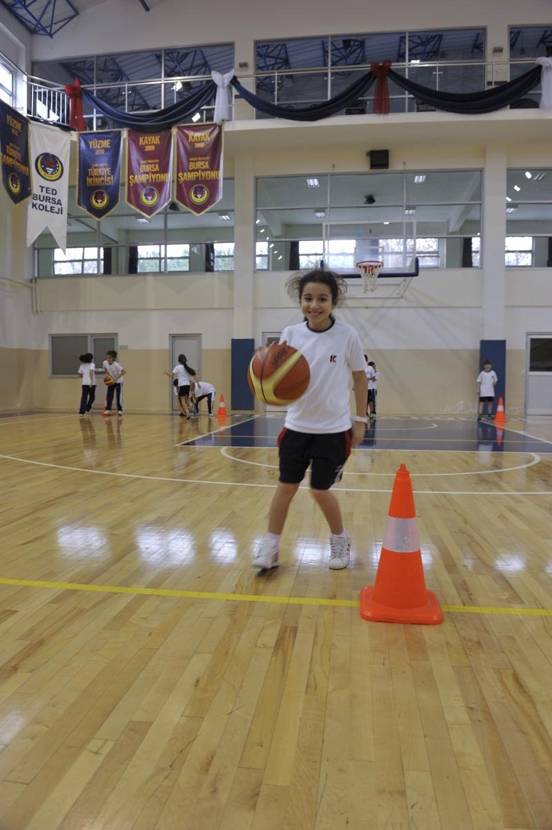 Spor salonunda basketbol çalışan öğrenci